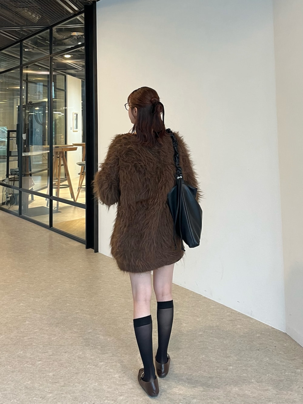 ブラウン系のカーディガン/ボレロ、ホワイト系のキャミソール、ブラック系のスカートを着用したレディースの秋コーディネートの3枚目の写真