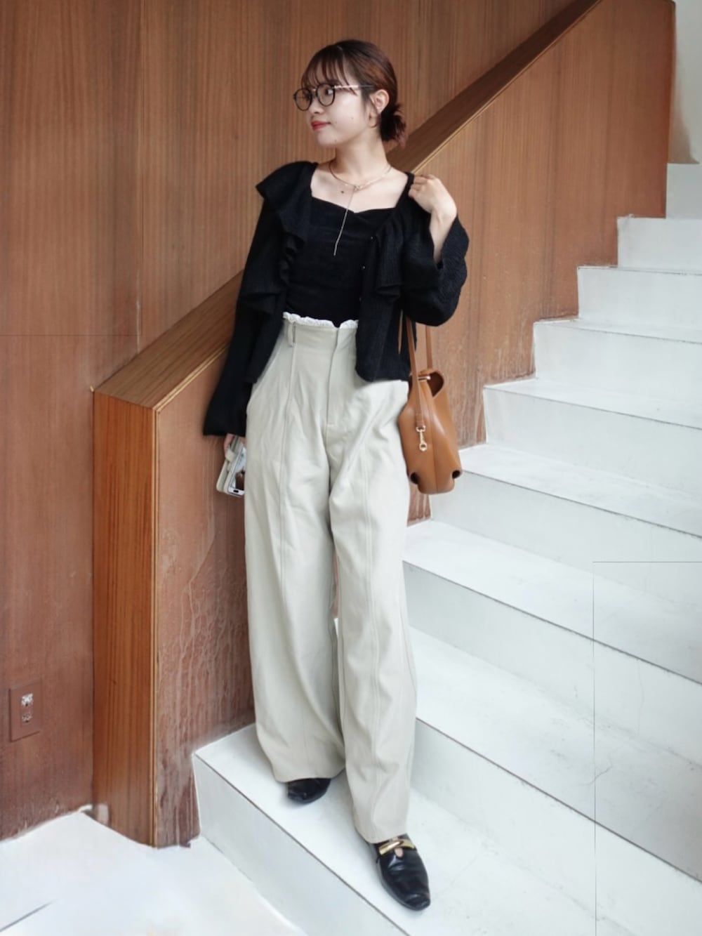 ブラック系のカーディガン/ボレロ、ブラック系のキャミソール、ベージュ系のその他パンツを着用したレディースの秋コーディネートの2枚目の写真