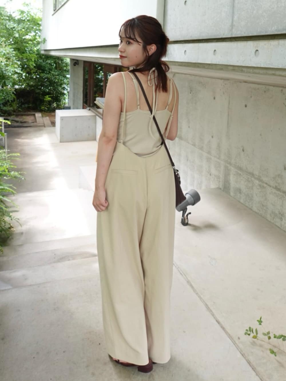 ブラウン系のショルダーバッグ、レッド系のサンダル、ベージュ系のサロペット/オーバーオールを着用したレディースの夏コーディネートの2枚目の写真