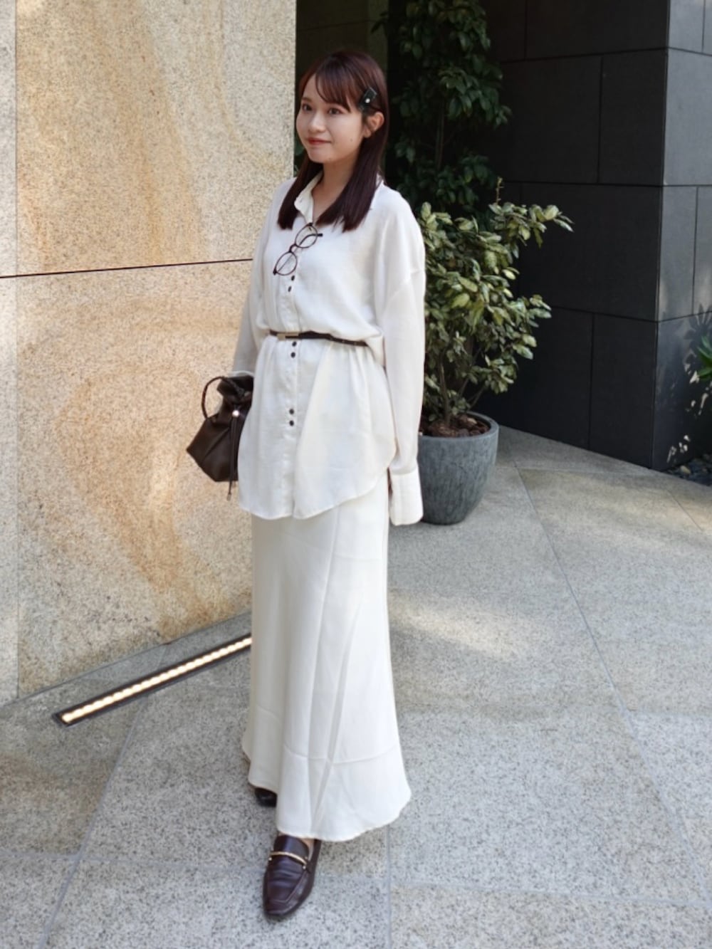 ホワイト系のシャツ/ブラウス、ホワイト系のスカート、ブラウン系のバッグを着用したレディースの秋コーディネートの2枚目の写真