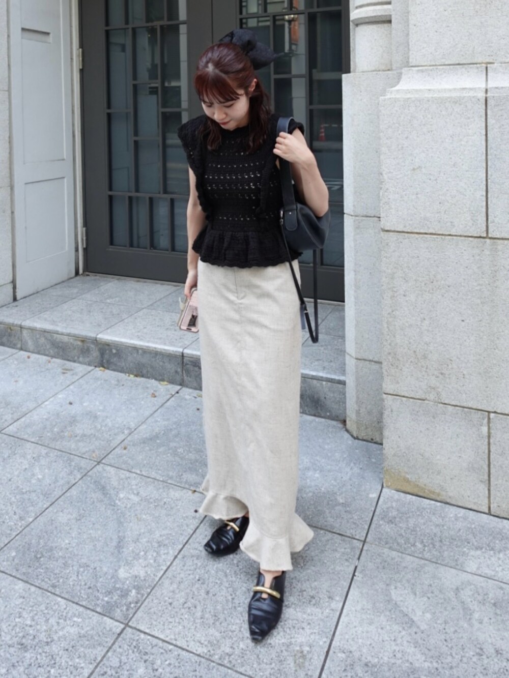 ブラック系のニット/セーター、ベージュ系のスカート、ブラック系のトートバッグを着用したレディースの秋コーディネートの3枚目の写真