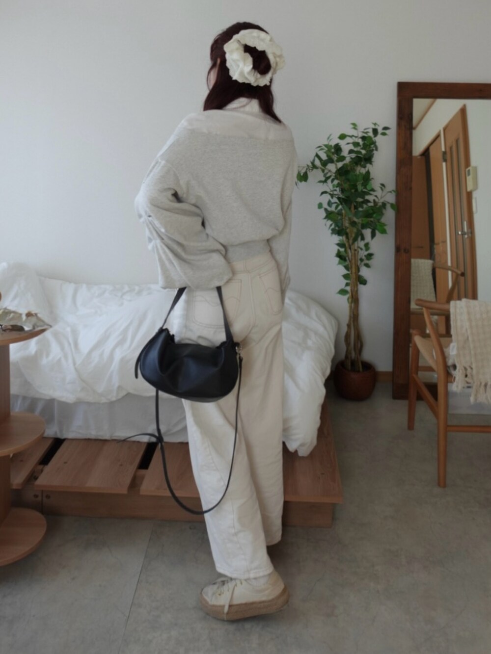 グレー系のスウェット、ホワイト系のデニムパンツ、ホワイト系のスニーカーを着用したレディースの春コーディネートの3枚目の写真