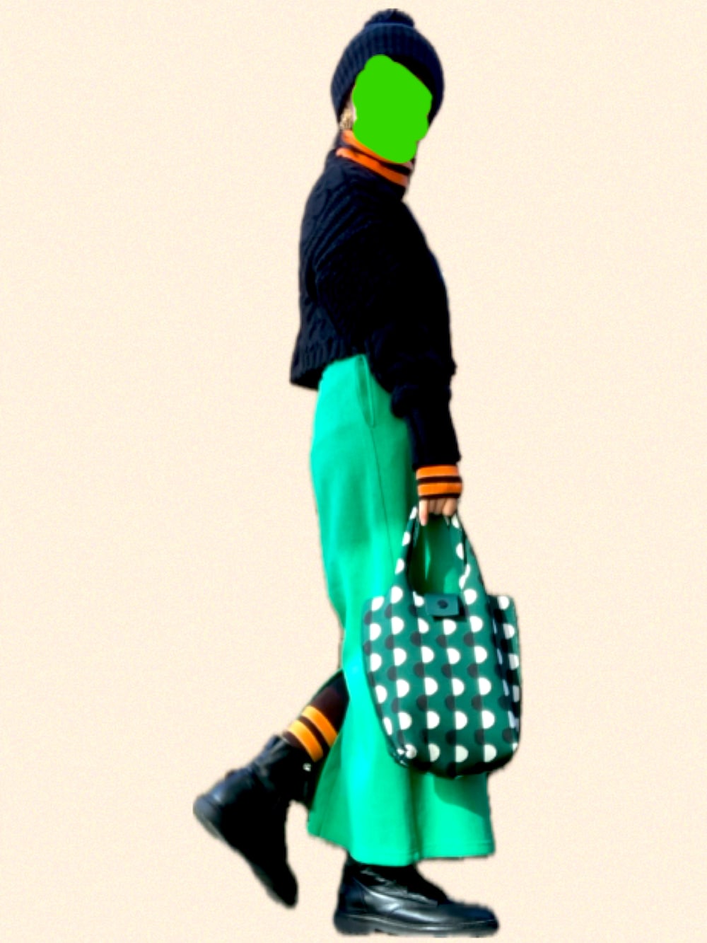 ブラック系のブーツ、オレンジ系のトップス、グリーン系のスカートを着用したレディースの冬コーディネートの3枚目の写真