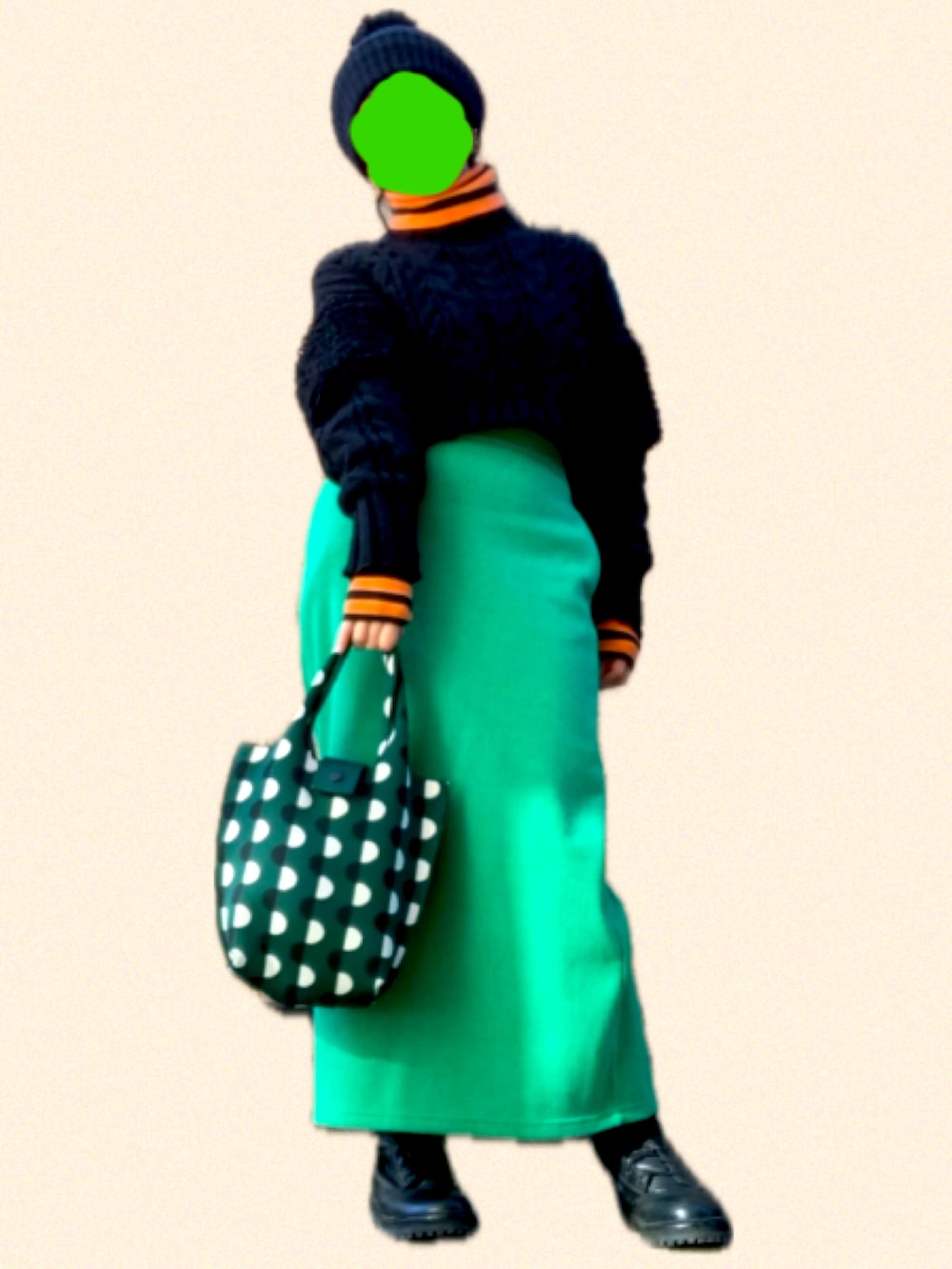 ブラック系のブーツ、オレンジ系のトップス、グリーン系のスカートを着用したレディースの冬コーディネートの2枚目の写真