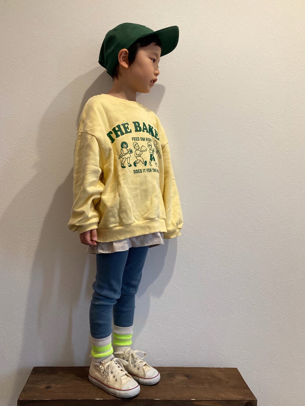 イエロー系のスウェット、ベージュ系のTシャツ/カットソー、ホワイト系のスニーカーを着用したキッズの冬コーディネートの2枚目の写真
