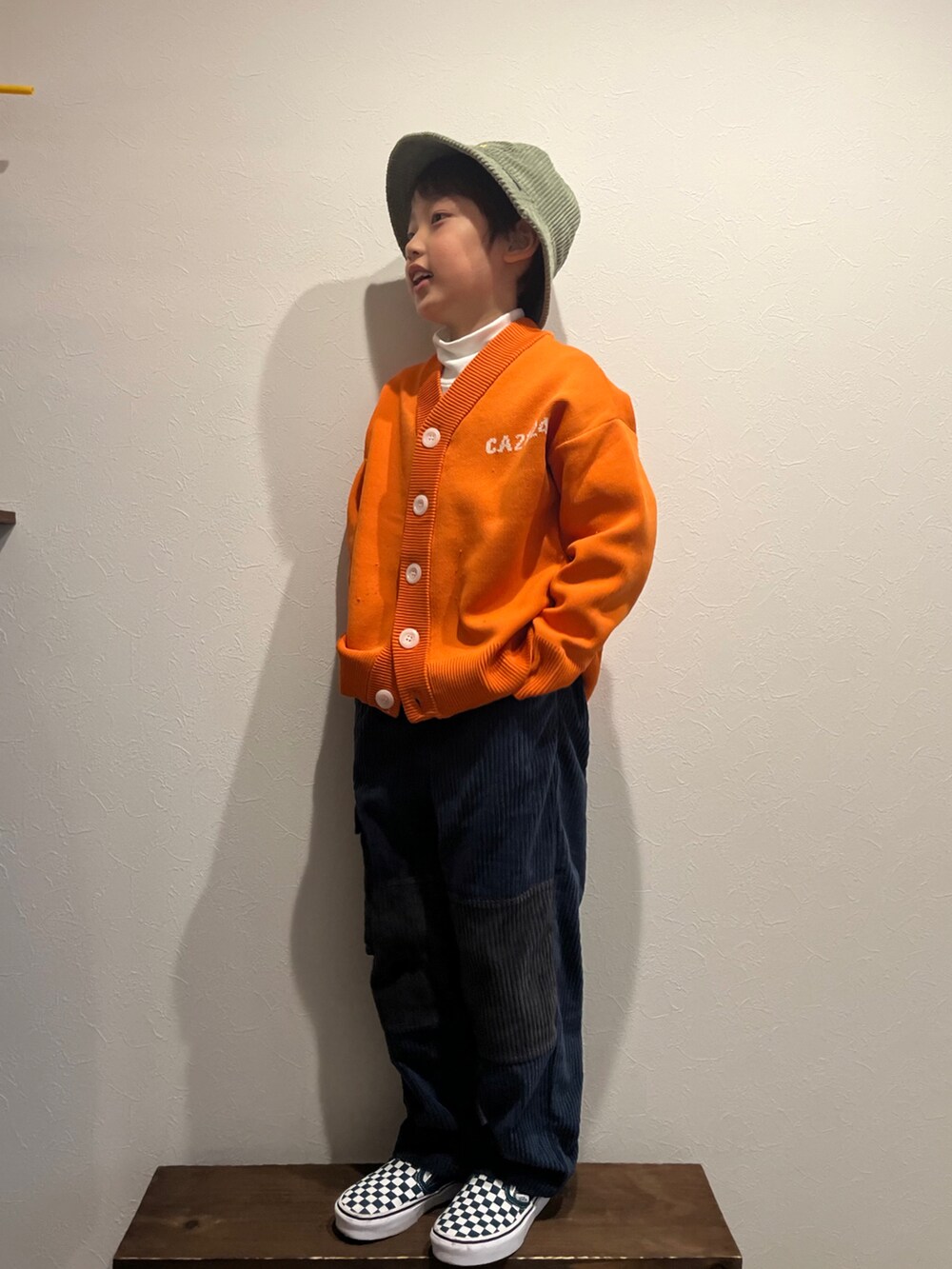オレンジ系のカーディガン/ボレロ、ホワイト系のTシャツ/カットソー、ブルー系のカーゴパンツを着用したキッズの春コーディネートの2枚目の写真