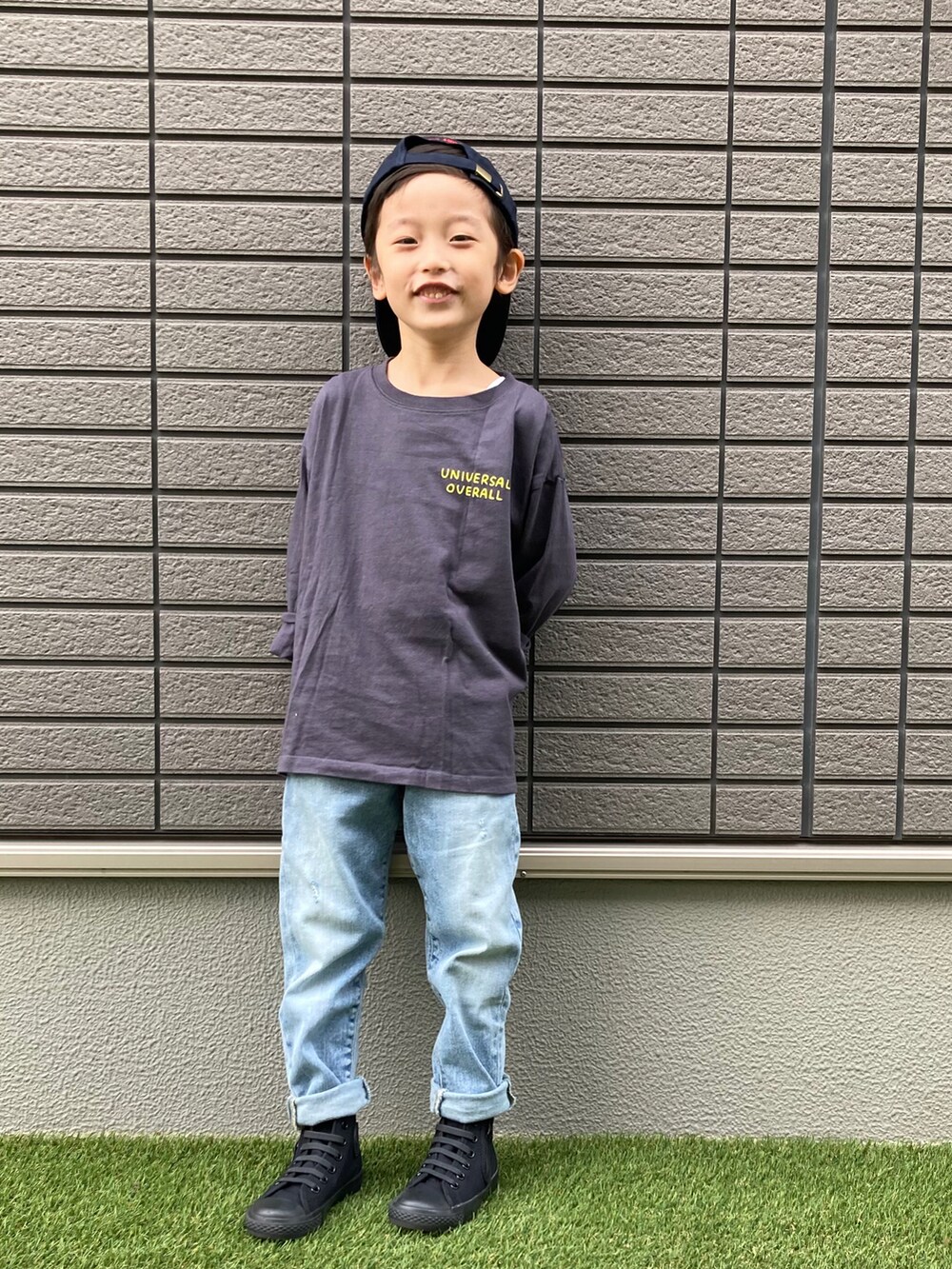 グレー系のTシャツ/カットソー、ブルー系のデニムパンツ、ブラック系のスニーカーを着用したキッズの秋コーディネートの2枚目の写真