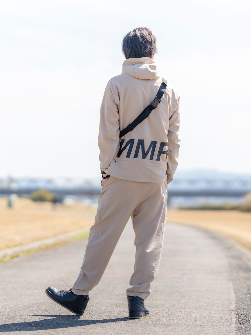 ベージュ系のジャケット/アウター、ブラック系のショルダーバッグ、ベージュ系のその他パンツを着用したメンズの春コーディネートの2枚目の写真