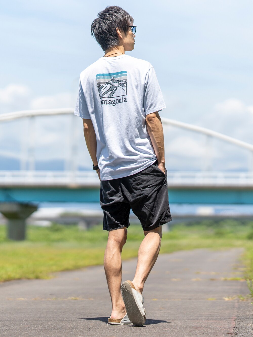 ホワイト系のTシャツ/カットソー、ブラック系のその他パンツ、ブラック系のサンダルを着用したメンズの夏コーディネートの4枚目の写真
