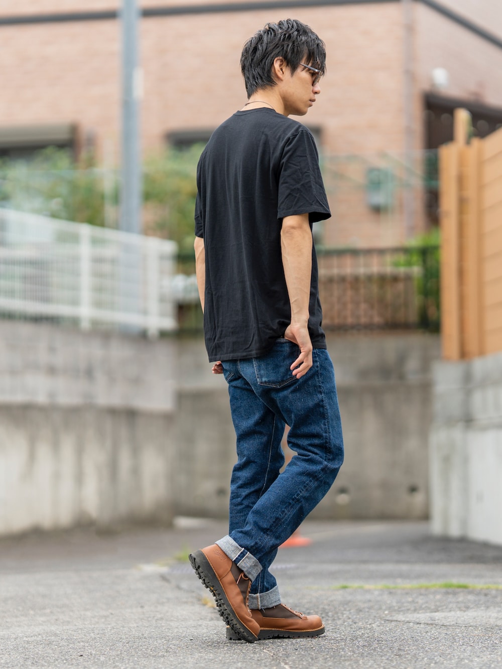 ブラック系のTシャツ/カットソー、ブルー系のデニムパンツ、ブラウン系のブーツを着用したメンズの秋コーディネートの2枚目の写真