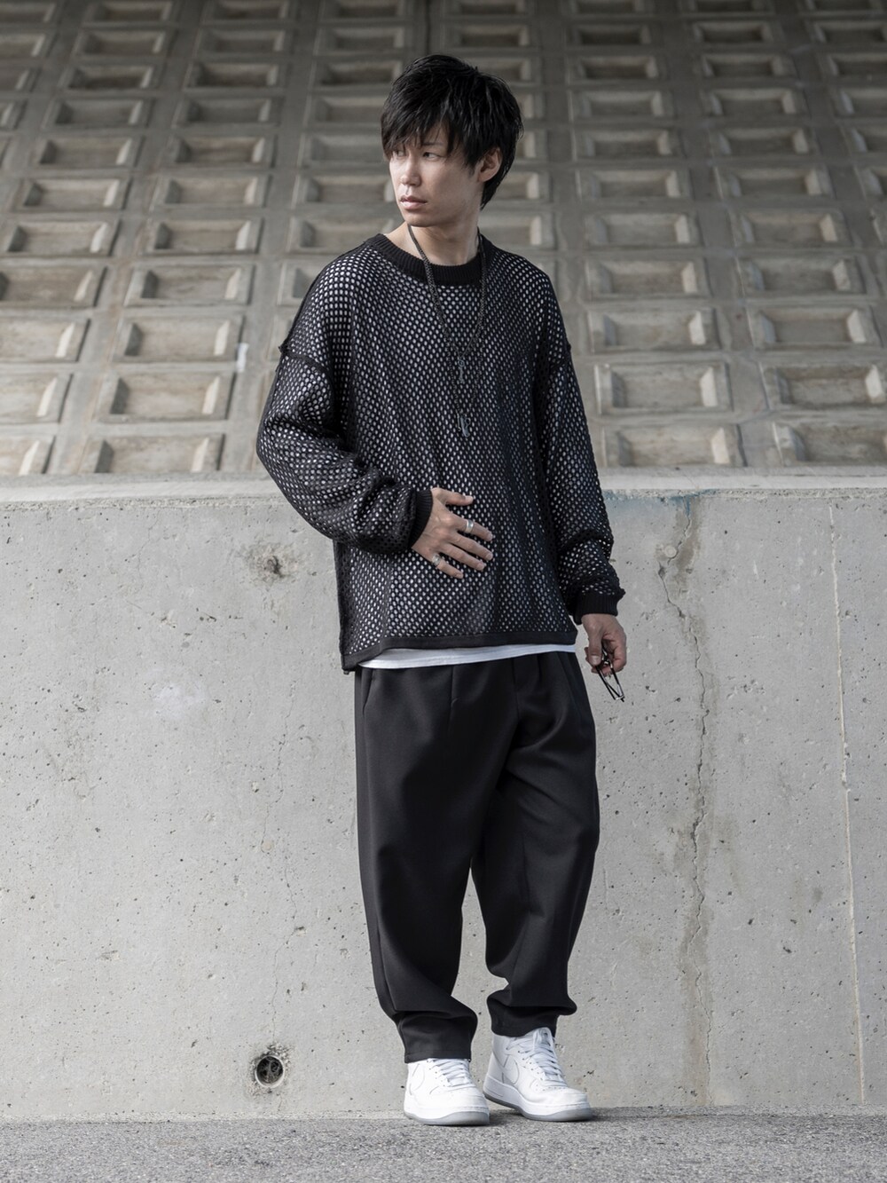 ブラック系のニット/セーター、ホワイト系のTシャツ/カットソー、ブラック系のパンツを着用したメンズの秋コーディネートの3枚目の写真
