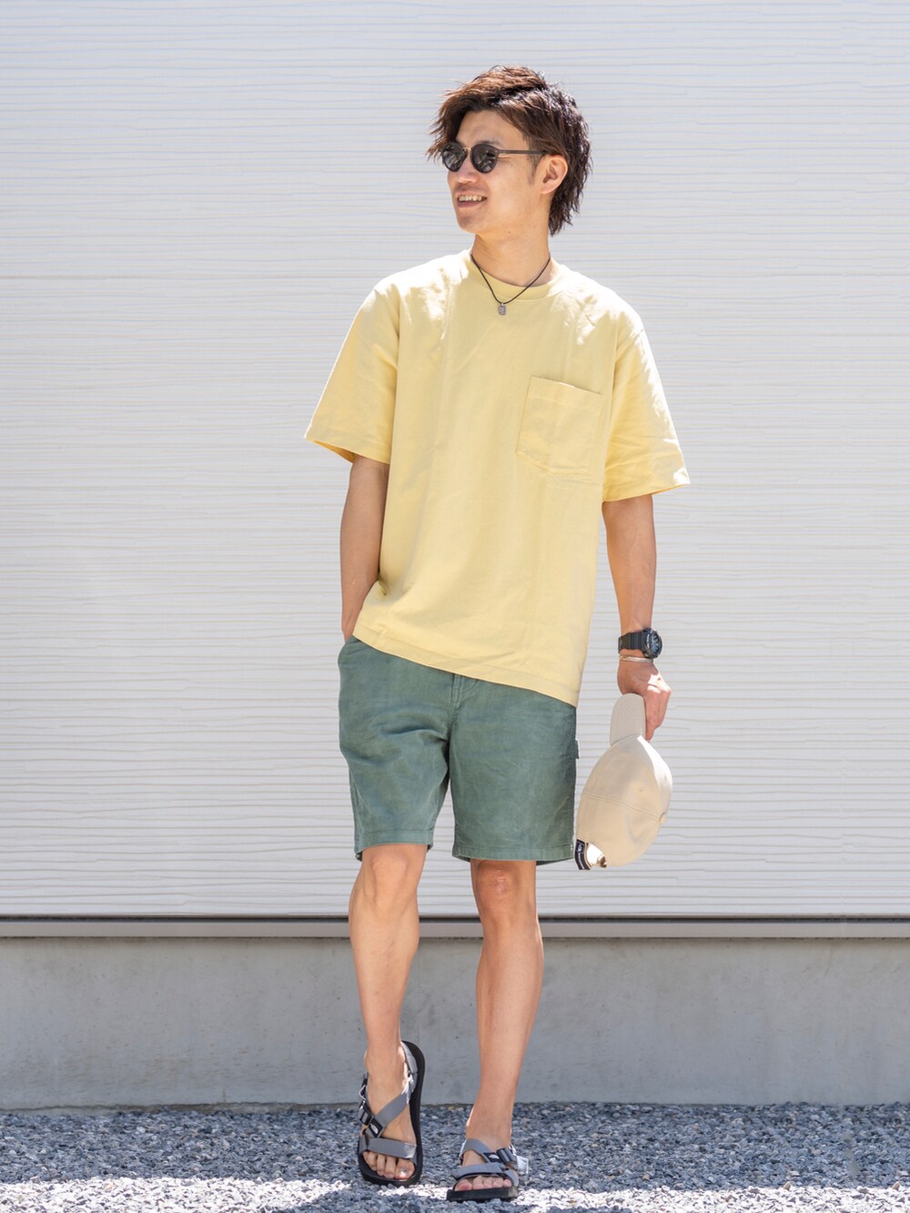 イエロー系のTシャツ/カットソー、グリーン系のパンツ、グレー系のサンダルを着用したメンズの夏コーディネートの2枚目の写真