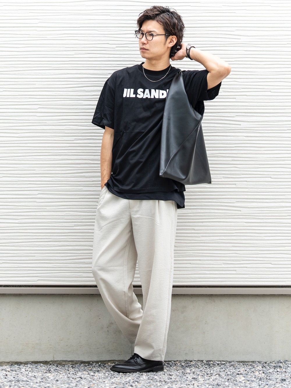 ブラック系のTシャツ/カットソー、ホワイト系のスラックス、ブラック系のトートバッグを着用したメンズの夏コーディネートの2枚目の写真