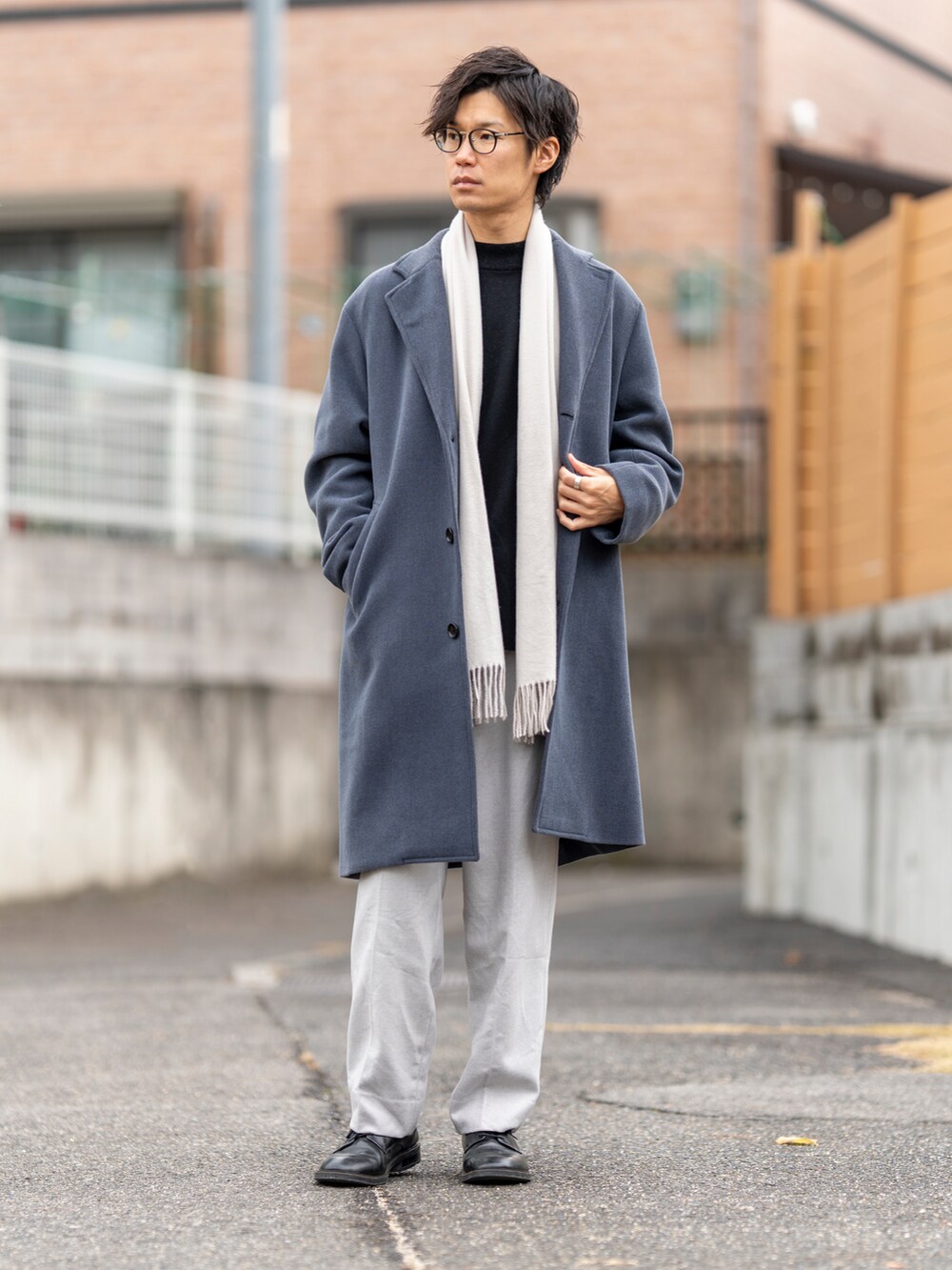 ブルー系のチェスターコート、ブラック系のニット/セーター、ブラック系のシューズを着用したメンズの冬コーディネートの4枚目の写真