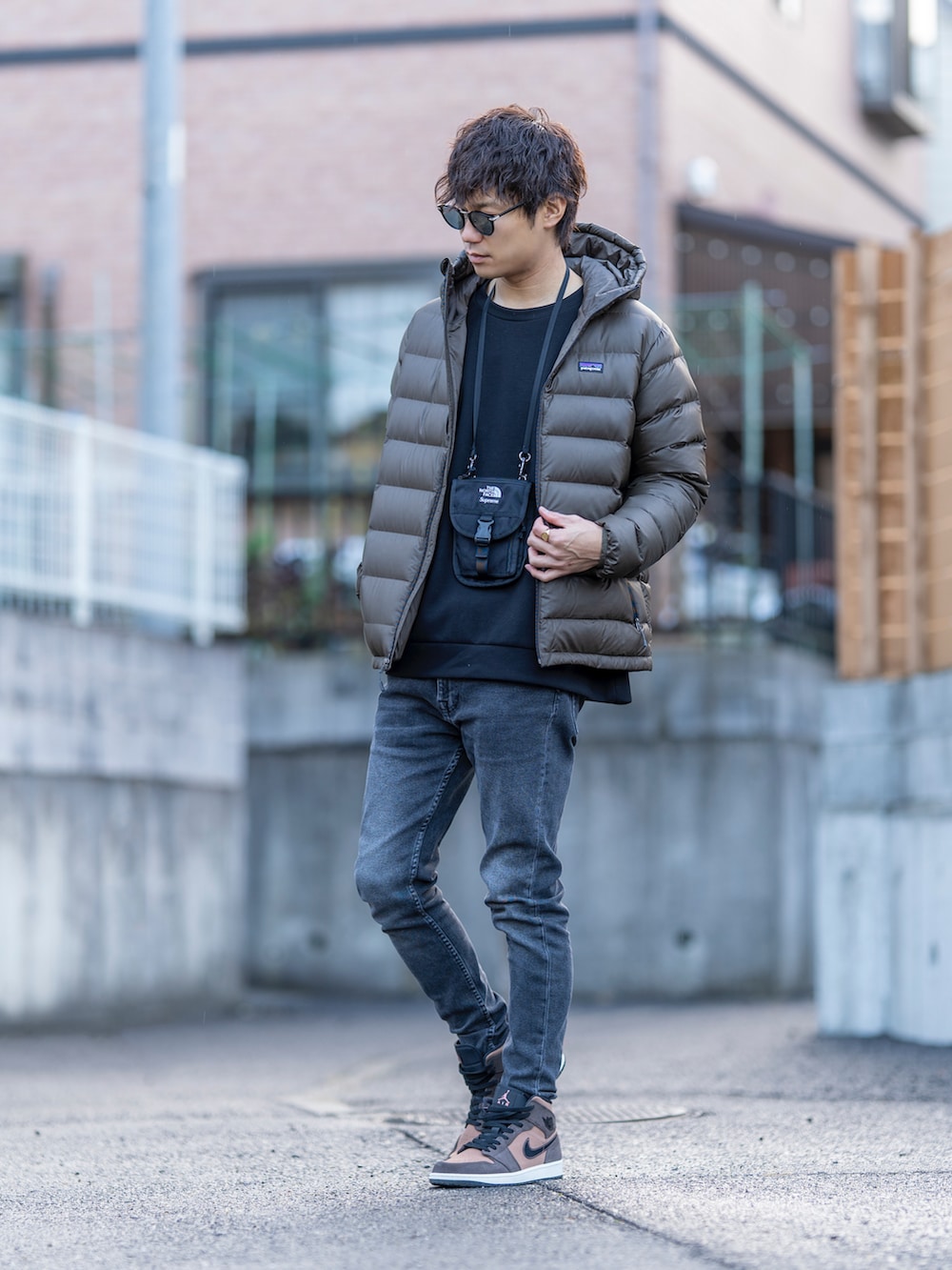 ブラウン系のダウンジャケット/コート、ブラック系のスウェット、ブラック系のショルダーバッグを着用したメンズの冬コーディネートの2枚目の写真