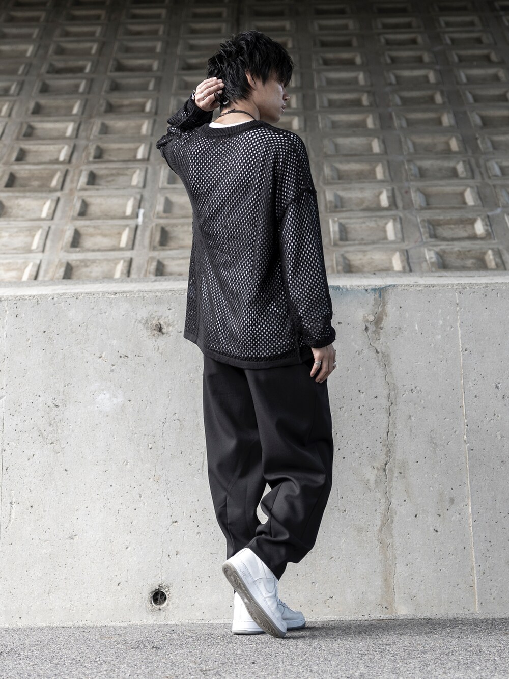 ブラック系のニット/セーター、ホワイト系のTシャツ/カットソー、ブラック系のパンツを着用したメンズの秋コーディネートの2枚目の写真