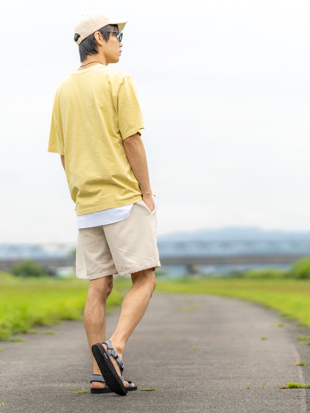 イエロー系のTシャツ/カットソー、ホワイト系のタンクトップ、ベージュ系のパンツを着用したメンズの夏コーディネートの2枚目の写真