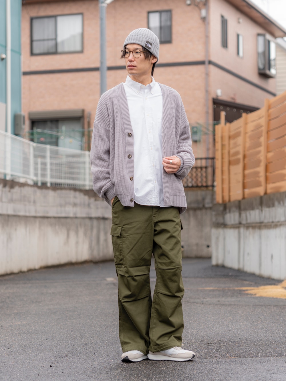 グレー系のカーディガン/ボレロ、ホワイト系のトップス、グリーン系のカーゴパンツを着用したメンズの冬コーディネートの2枚目の写真