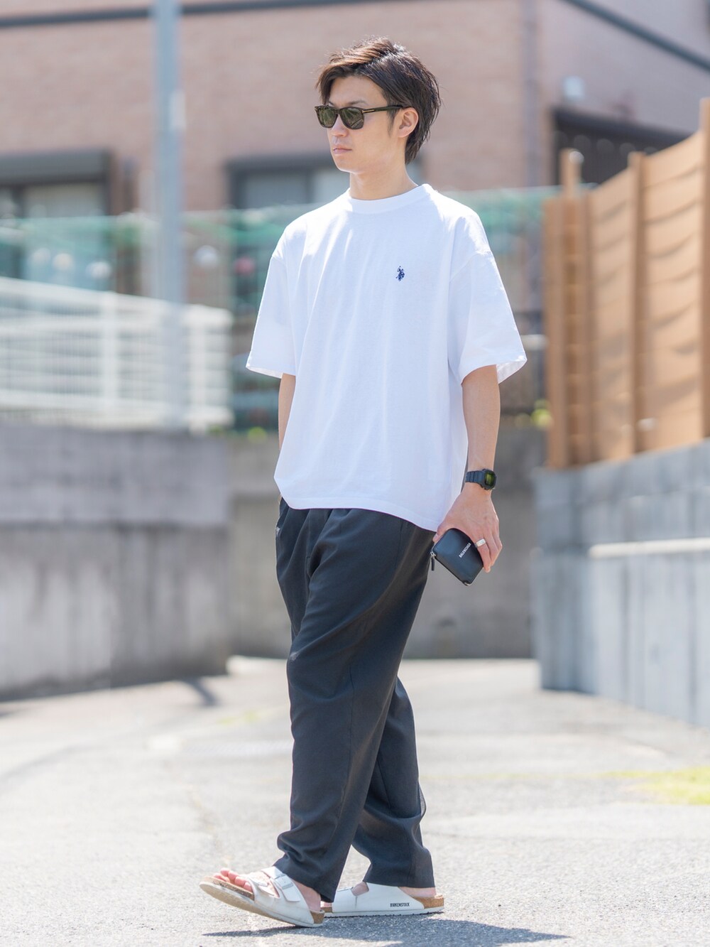 ホワイト系のTシャツ/カットソー、ブラック系のその他パンツ、ホワイト系のサンダルを着用したメンズの春コーディネートの3枚目の写真