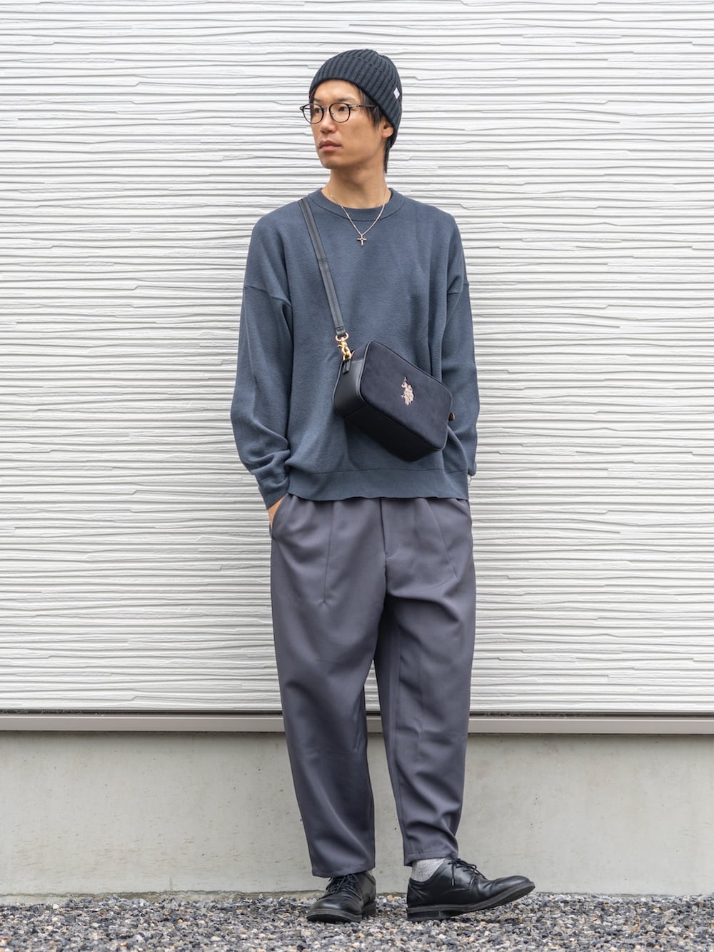 ブルー系のトップス、ブラック系のショルダーバッグ、グレー系のパンツを着用したメンズの秋コーディネートの2枚目の写真