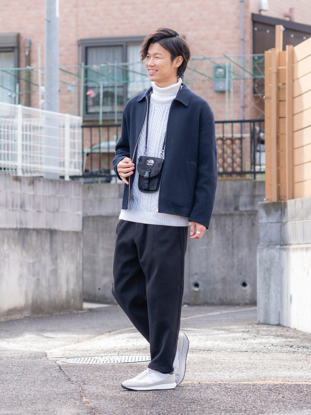 ブルー系のブルゾン、ホワイト系のニット/セーター、ブラック系のパンツを着用したメンズの冬コーディネートの2枚目の写真
