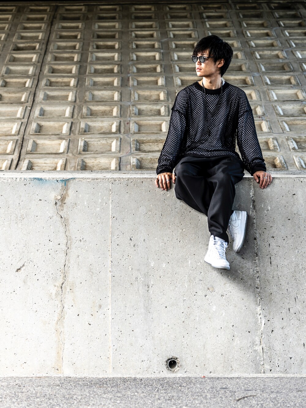 ブラック系のニット/セーター、ホワイト系のTシャツ/カットソー、ブラック系のパンツを着用したメンズの秋コーディネートの4枚目の写真