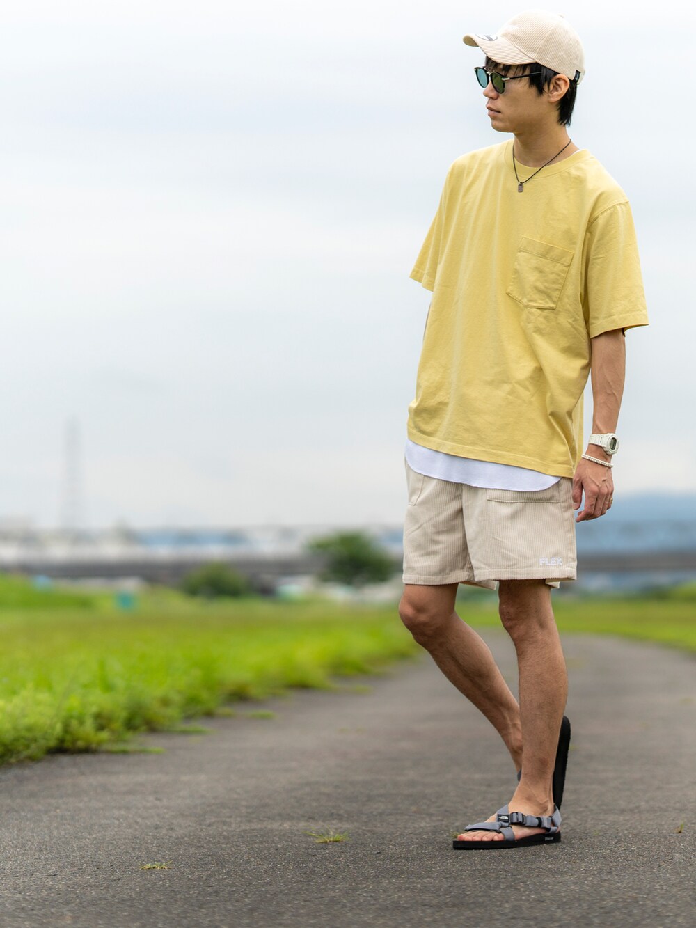 イエロー系のTシャツ/カットソー、ホワイト系のタンクトップ、ベージュ系のパンツを着用したメンズの夏コーディネートの3枚目の写真