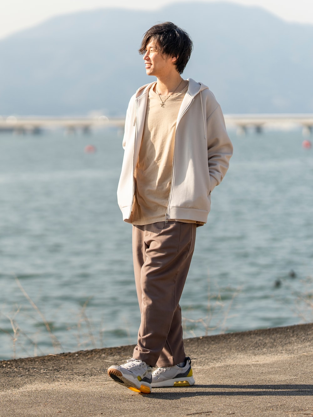 グレー系のパーカー、ベージュ系のTシャツ/カットソー、ブラウン系のパンツを着用したメンズの春コーディネートの2枚目の写真