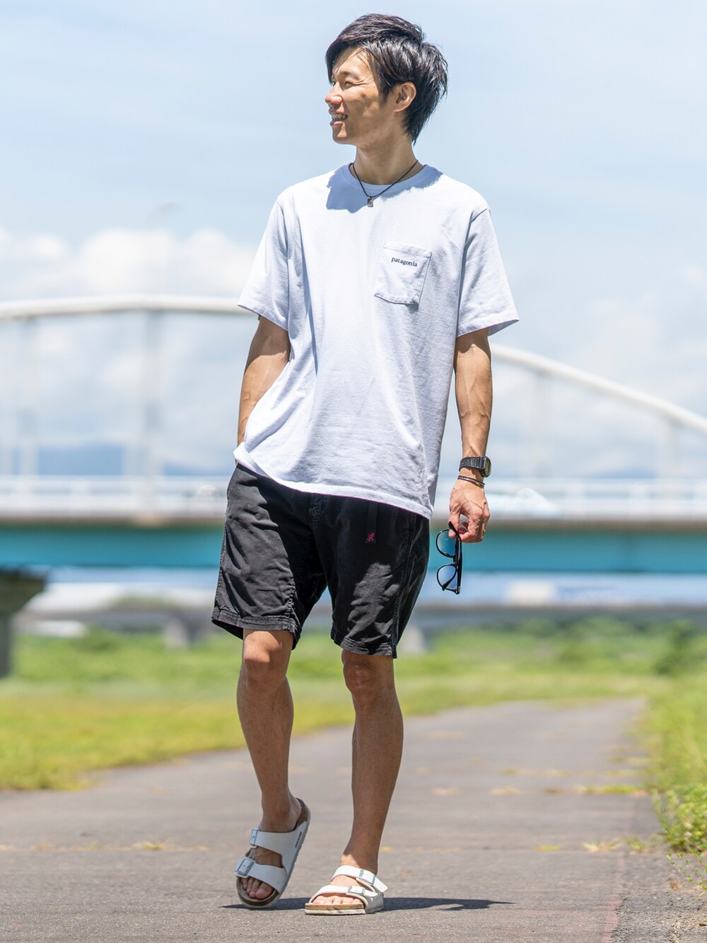 ホワイト系のTシャツ/カットソー、ブラック系のその他パンツ、ブラック系のサンダルを着用したメンズの夏コーディネートの3枚目の写真