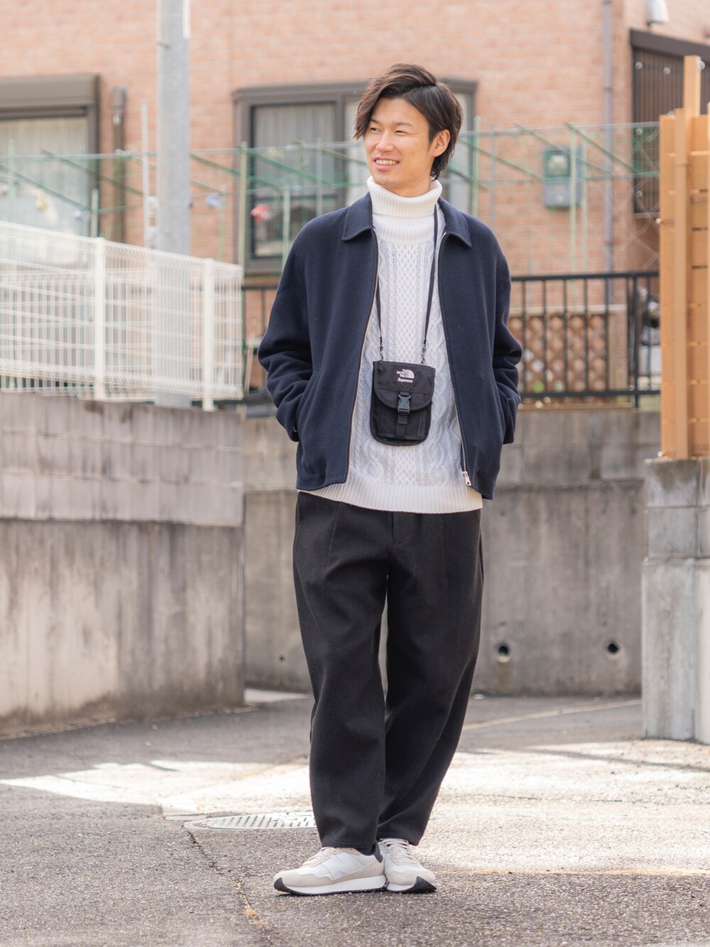 ブルー系のブルゾン、ホワイト系のニット/セーター、ブラック系のパンツを着用したメンズの冬コーディネートの3枚目の写真