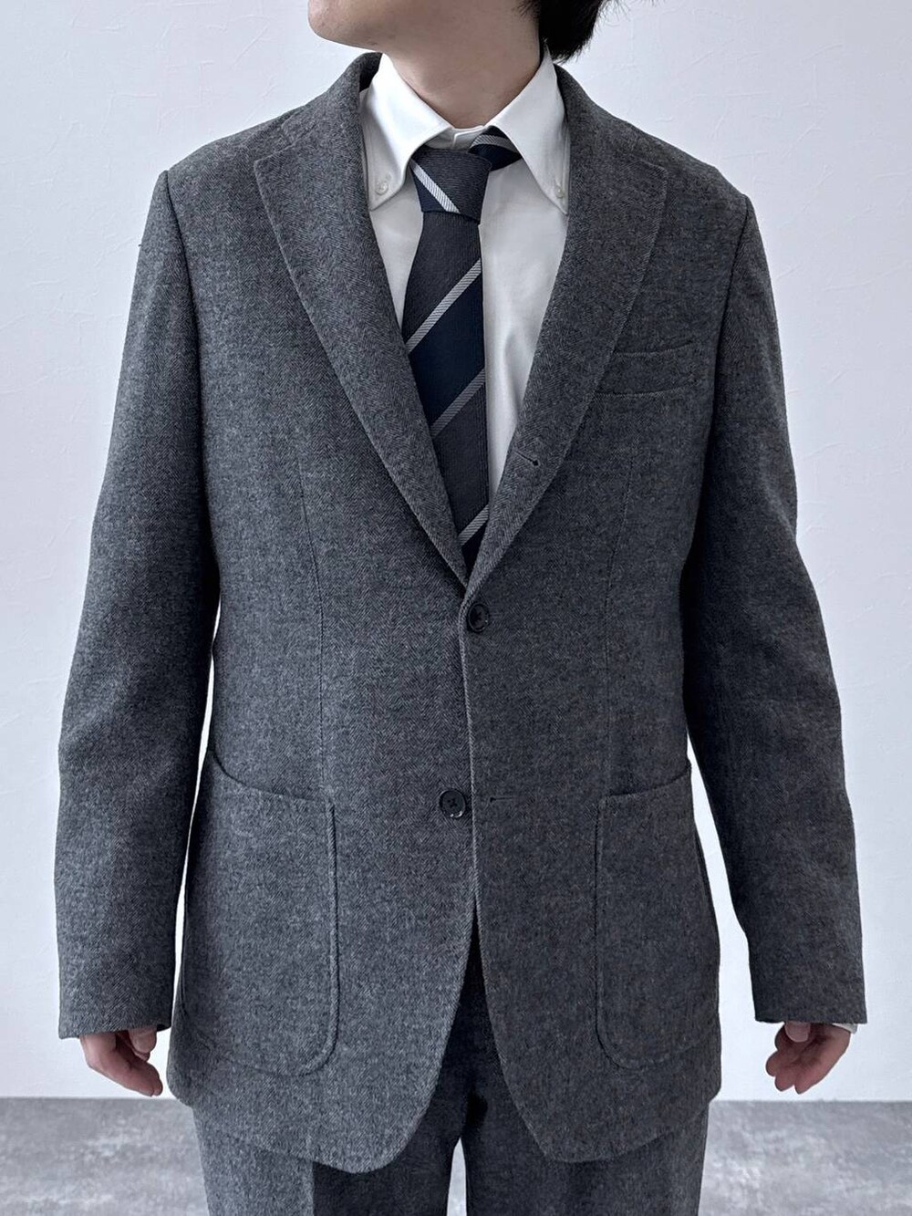 ブラック系のその他シューズ、グレー系のテーラードジャケット、グレー系のスラックスを着用したメンズの秋コーディネートの4枚目の写真