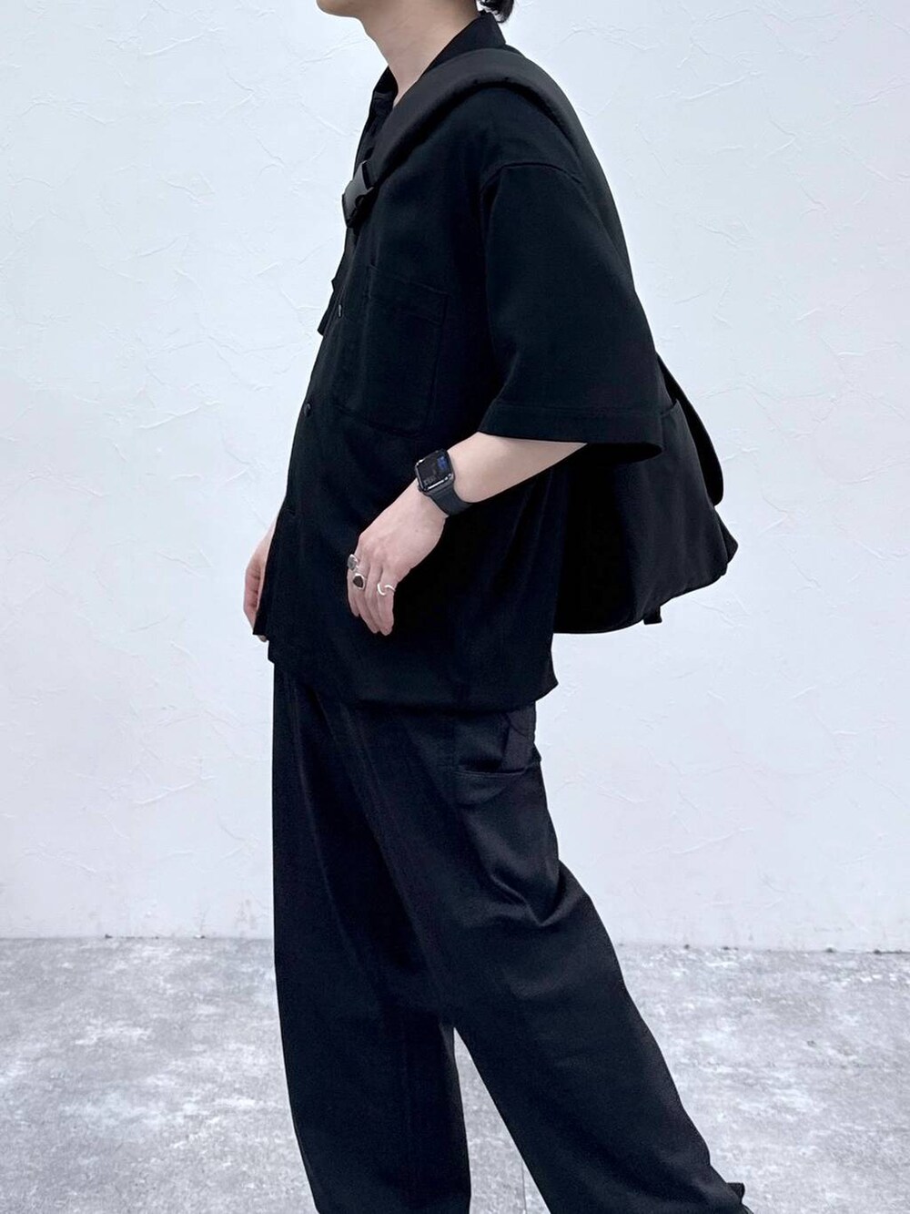 ブラック系のメッセンジャーバッグ、ブラック系のシャツ/ブラウス、ブルー系のデニムパンツを着用したメンズの春コーディネートの5枚目の写真