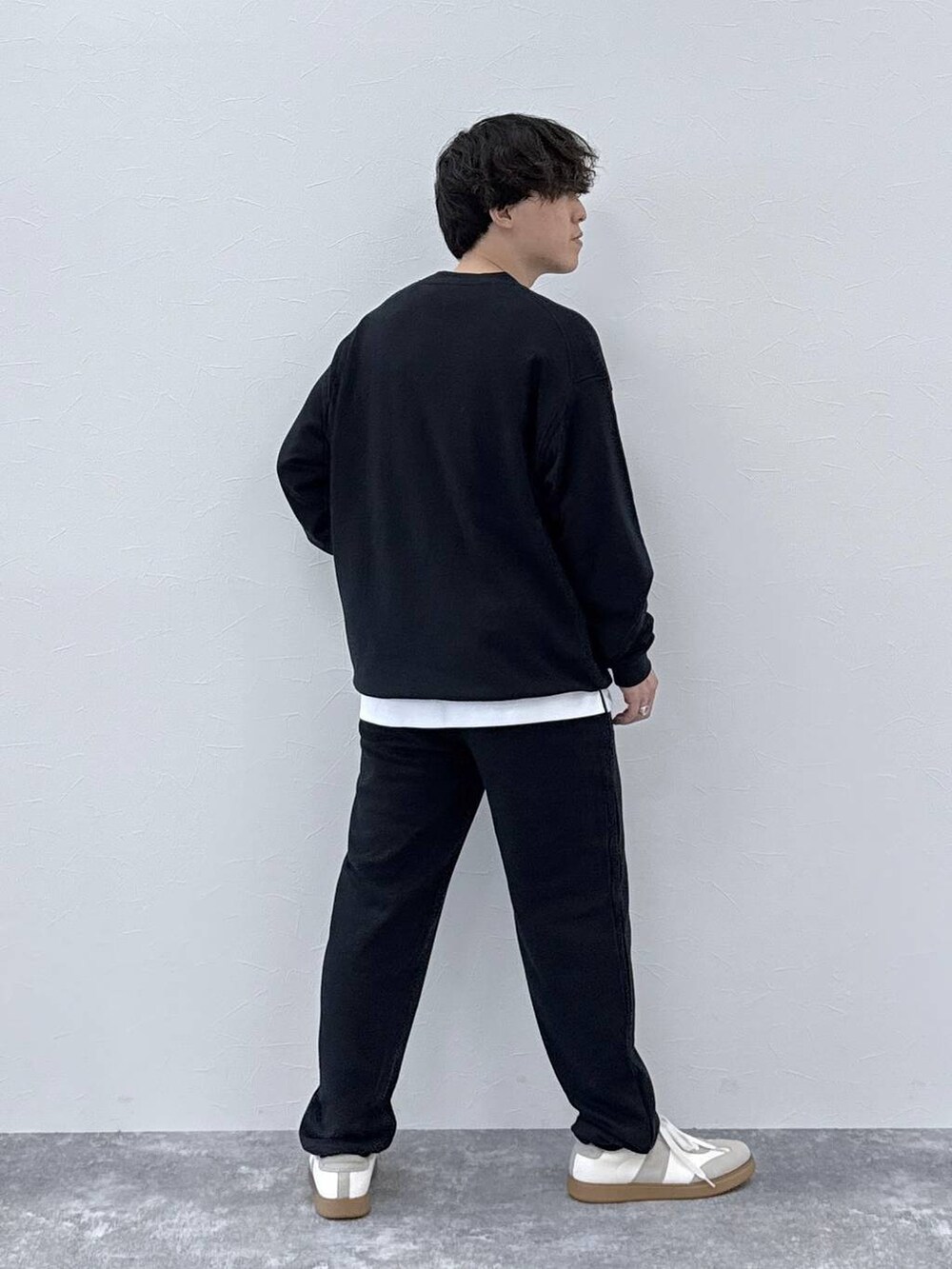 ベージュ系のスニーカー、ホワイト系のTシャツ/カットソー、ブラック系のTシャツ/カットソーを着用したメンズの秋コーディネートの3枚目の写真