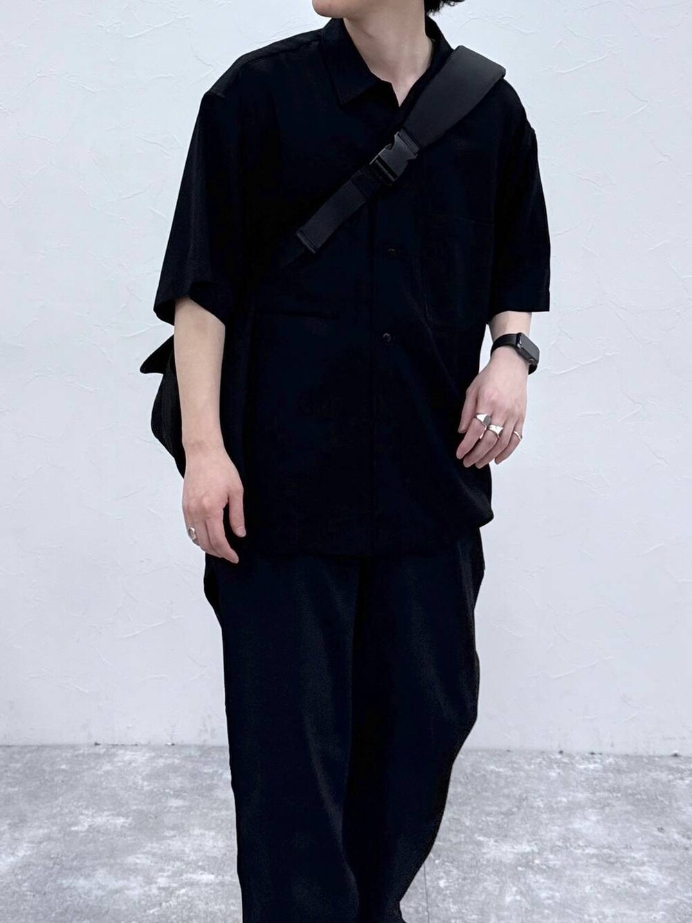 ブラック系のメッセンジャーバッグ、ブラック系のシャツ/ブラウス、ブルー系のデニムパンツを着用したメンズの春コーディネートの4枚目の写真