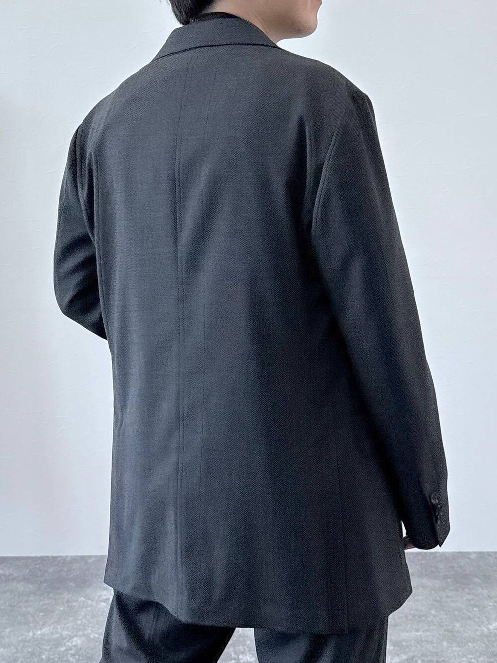 グレー系のテーラードジャケット、グレー系のスラックス、ブラウン系のニット/セーターを着用したメンズの秋コーディネートの5枚目の写真