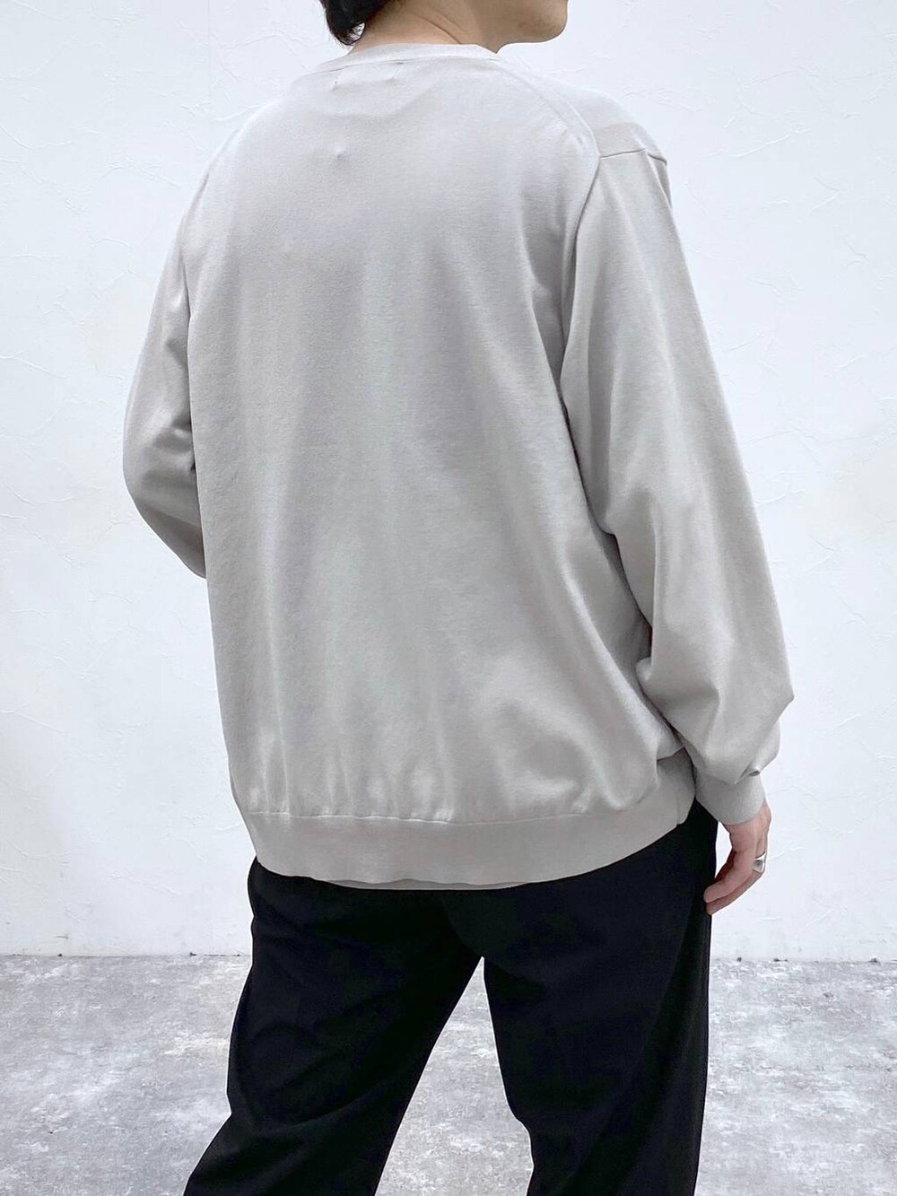 ブラック系のトートバッグ、ブラック系のスラックス、グレー系のニット/セーターを着用したメンズの春コーディネートの5枚目の写真