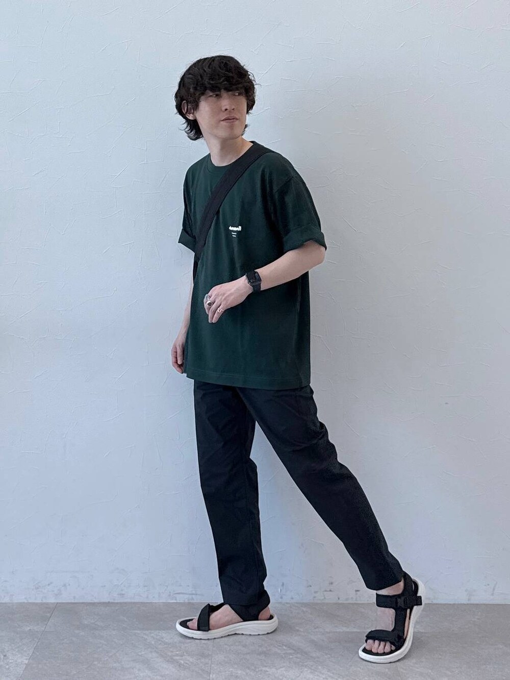 ブラック系のショルダーバッグ、グレー系のその他パンツ、グリーン系のTシャツ/カットソーを着用したメンズの夏コーディネートの2枚目の写真