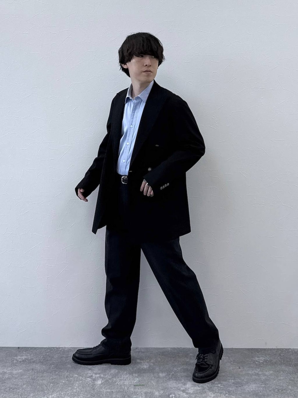 ブラック系のテーラードジャケット、ブラック系のデニムパンツ、ブルー系のシャツ/ブラウスを着用したメンズの秋コーディネートの2枚目の写真