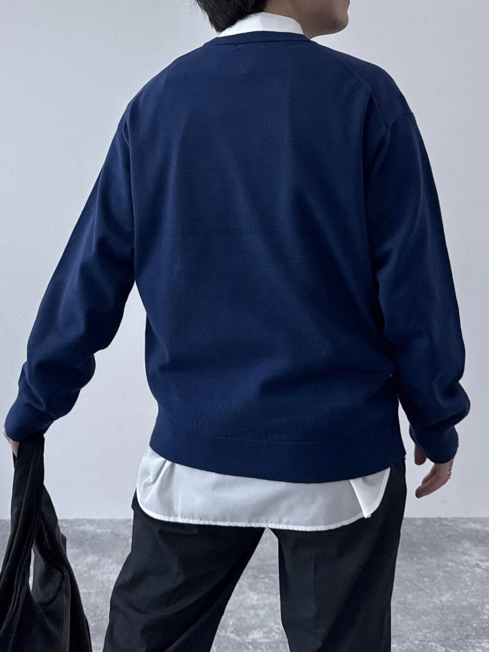 ブラック系のトートバッグ、ブラック系のその他シューズ、ブルー系のデニムパンツを着用したメンズの秋コーディネートの5枚目の写真