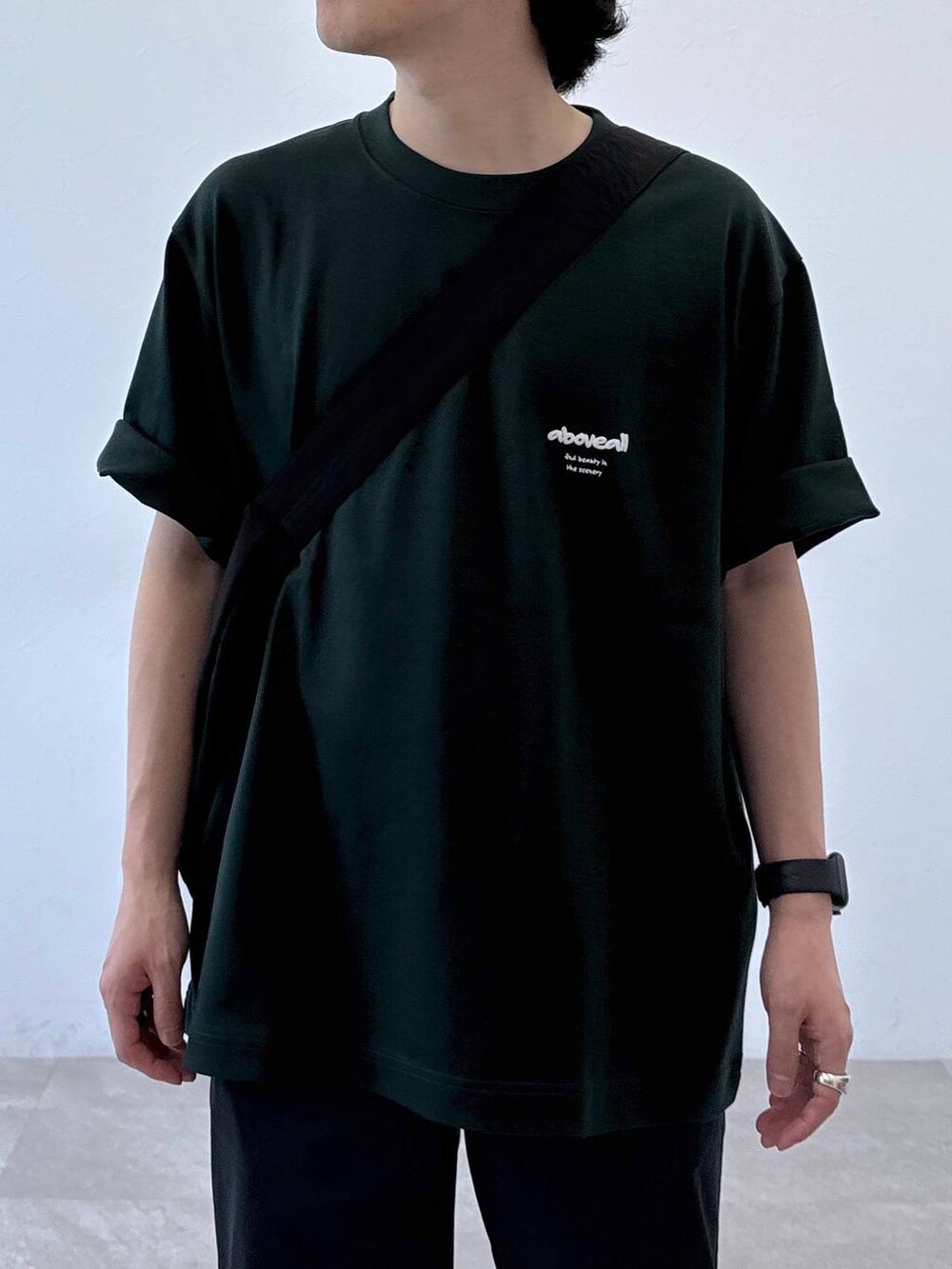 ブラック系のショルダーバッグ、グレー系のその他パンツ、グリーン系のTシャツ/カットソーを着用したメンズの夏コーディネートの4枚目の写真