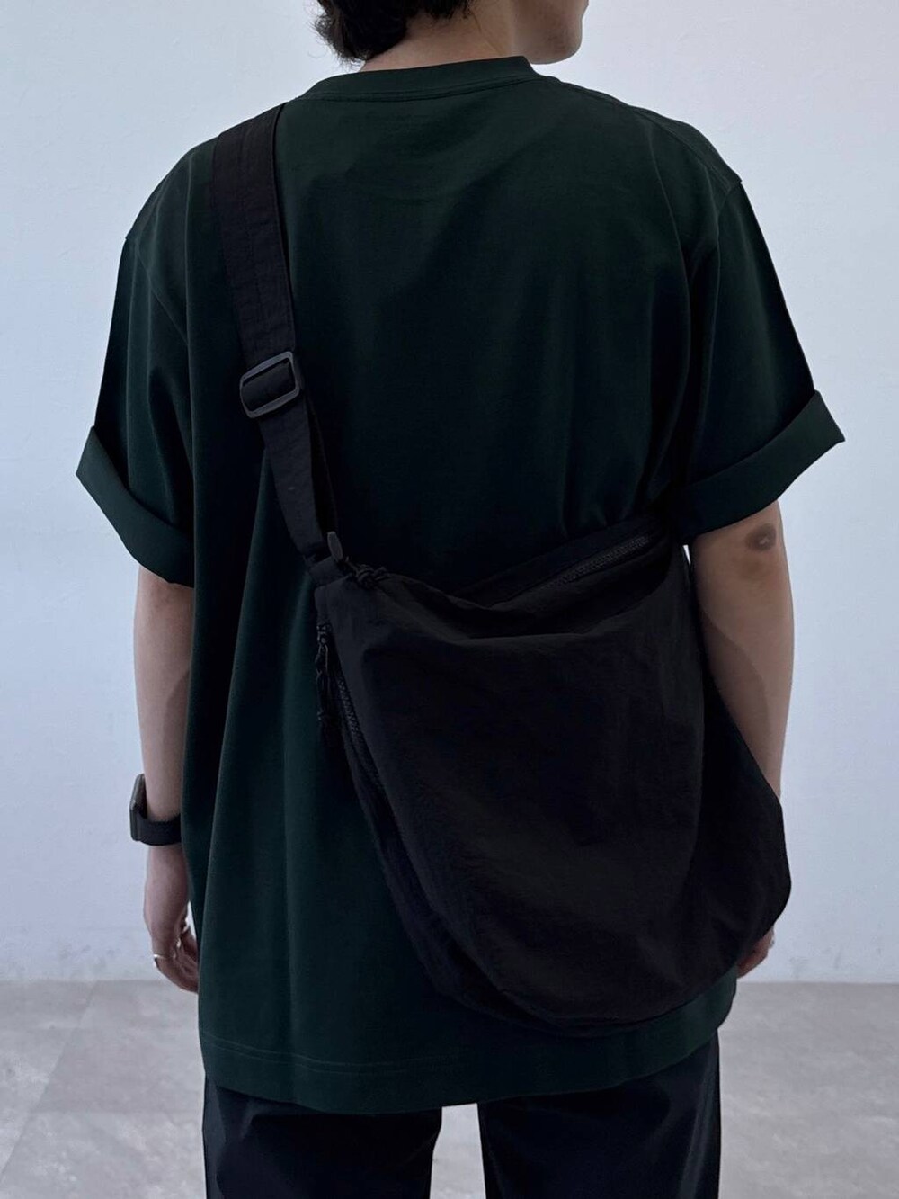 ブラック系のショルダーバッグ、グレー系のその他パンツ、グリーン系のTシャツ/カットソーを着用したメンズの夏コーディネートの5枚目の写真