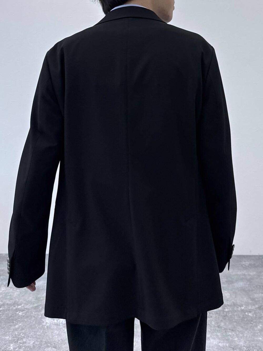 ブラック系のテーラードジャケット、ブラック系のデニムパンツ、ブルー系のシャツ/ブラウスを着用したメンズの秋コーディネートの5枚目の写真