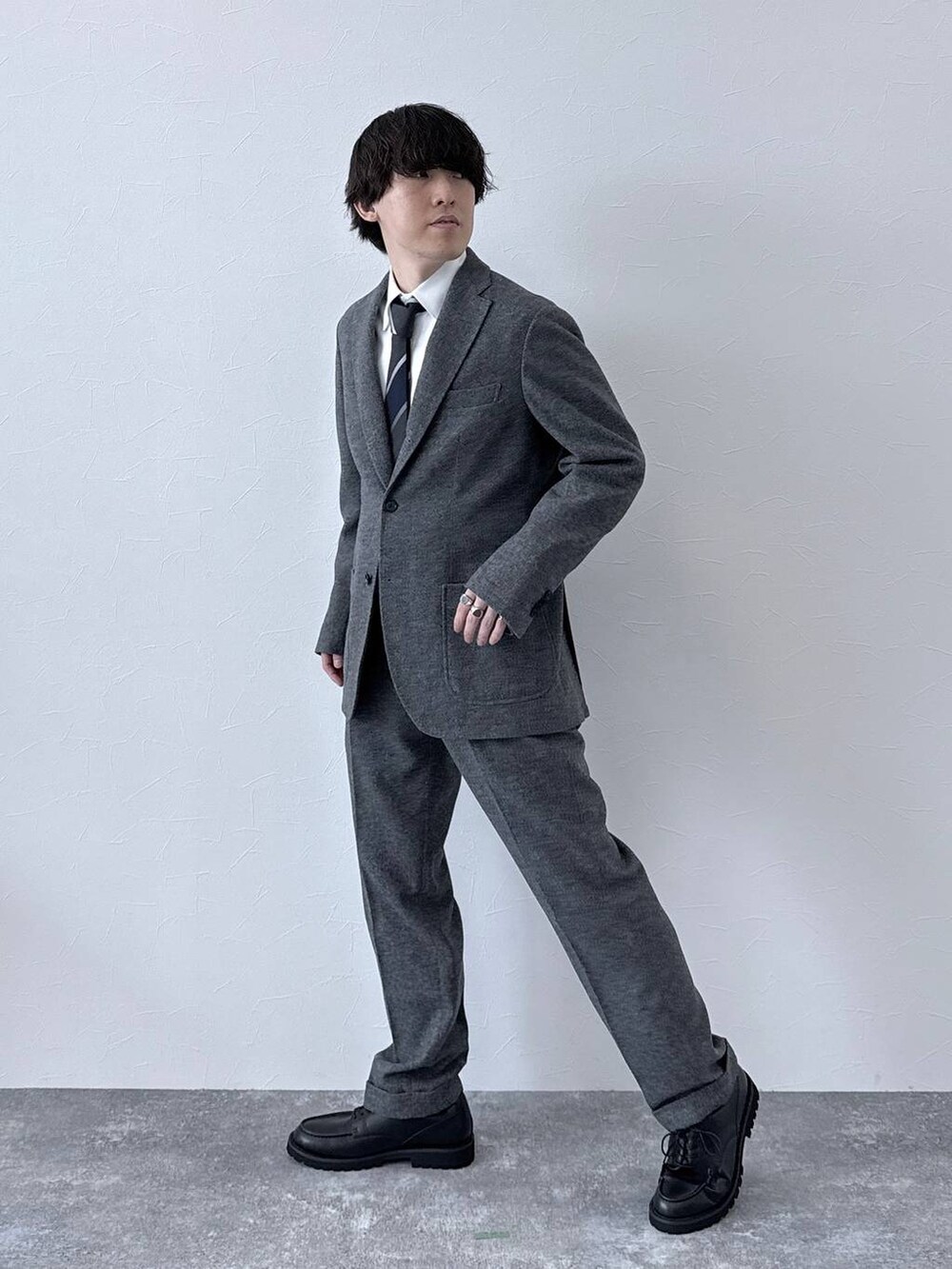 ブラック系のその他シューズ、グレー系のテーラードジャケット、グレー系のスラックスを着用したメンズの秋コーディネートの2枚目の写真