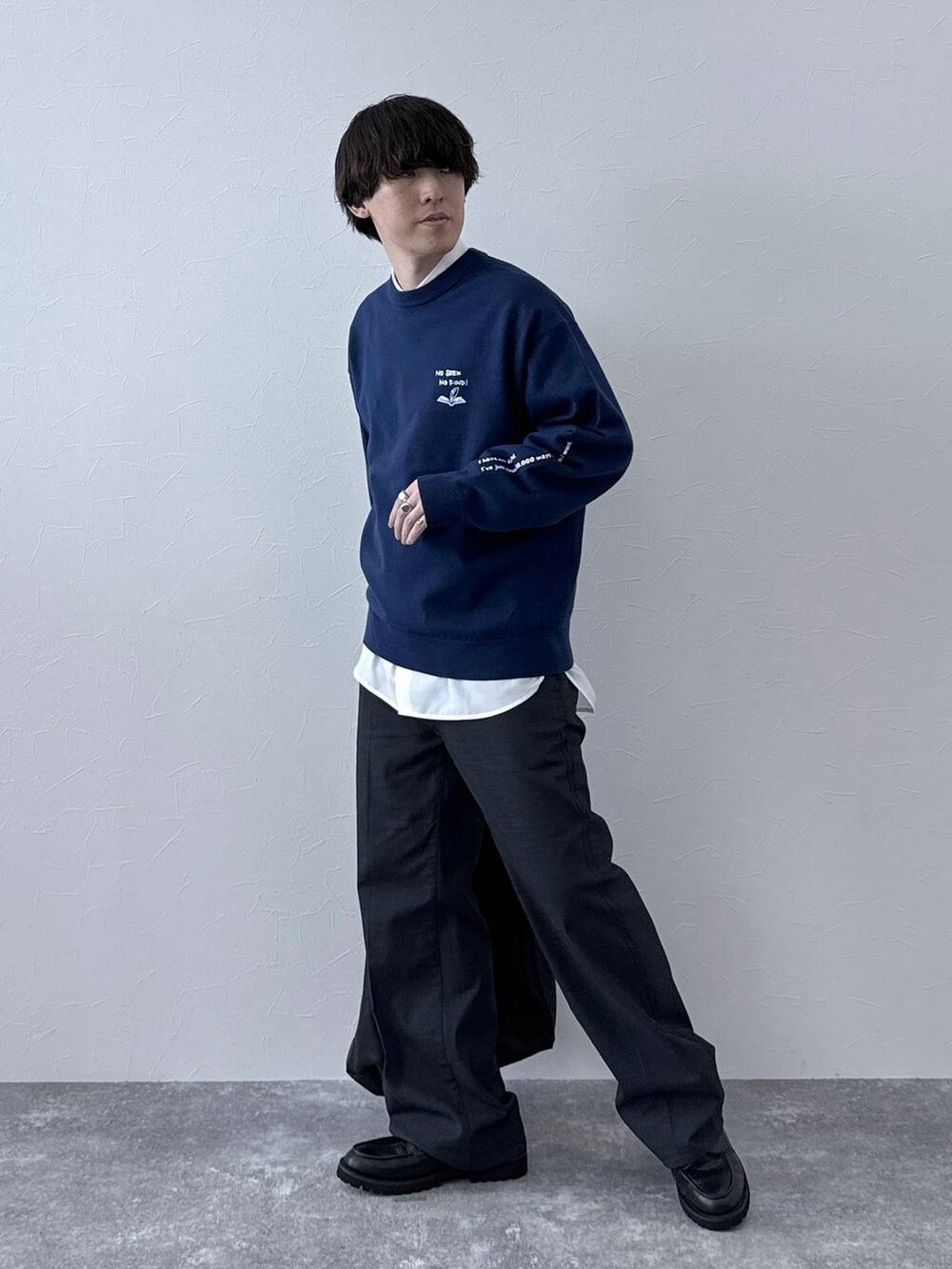 ブラック系のトートバッグ、ブラック系のその他シューズ、ブルー系のデニムパンツを着用したメンズの秋コーディネートの2枚目の写真