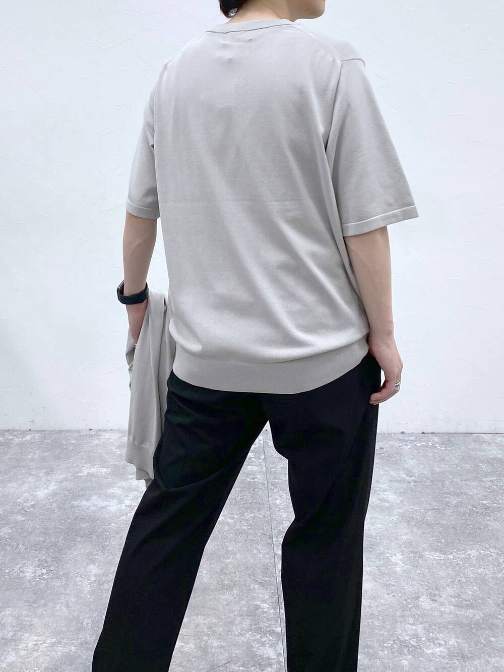 ブラック系のトートバッグ、ブラック系のスラックス、グレー系のニット/セーターを着用したメンズの春コーディネートの9枚目の写真