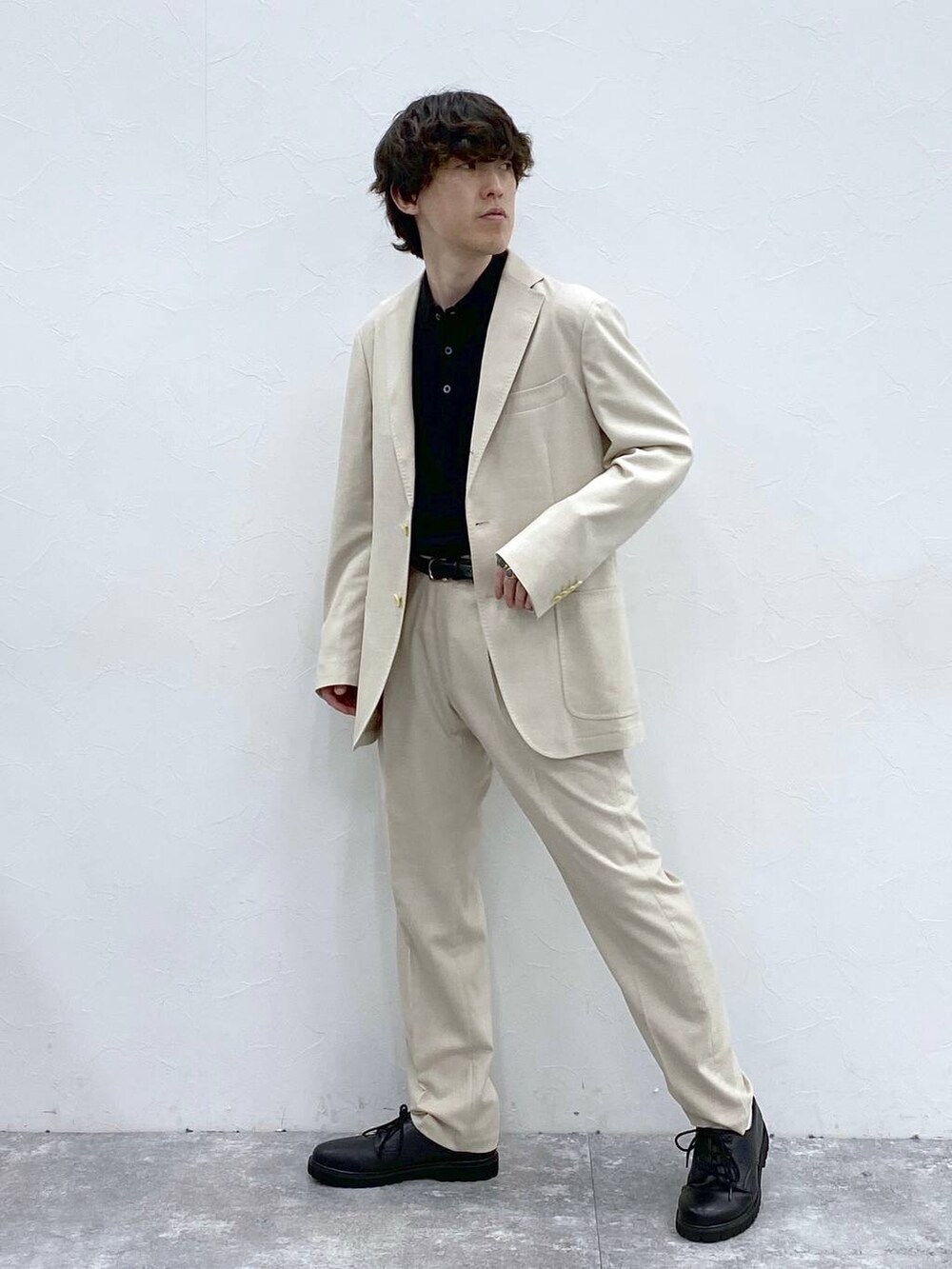 ホワイト系のテーラードジャケット、ホワイト系のその他パンツ、ブラック系のニット/セーターを着用したメンズの春コーディネートの3枚目の写真