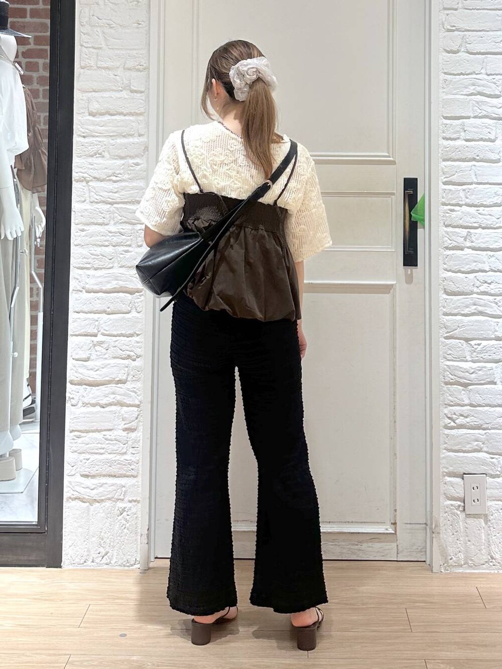 ブラウン系のキャミソール、ブラウン系のサンダル、ブラック系のショルダーバッグを着用したレディースの春コーディネートの2枚目の写真