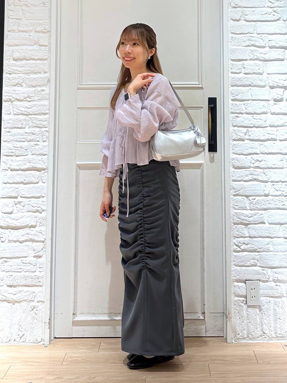 ブラック系のバレエシューズ、シルバー系のトートバッグ、グレー系のスカートを着用したレディースの春コーディネートの6枚目の写真