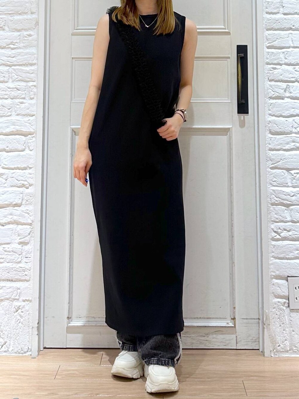 ブラック系のデニムパンツ、ブラック系のワンピース、ホワイト系のスニーカーを着用したレディースの夏コーディネートの4枚目の写真