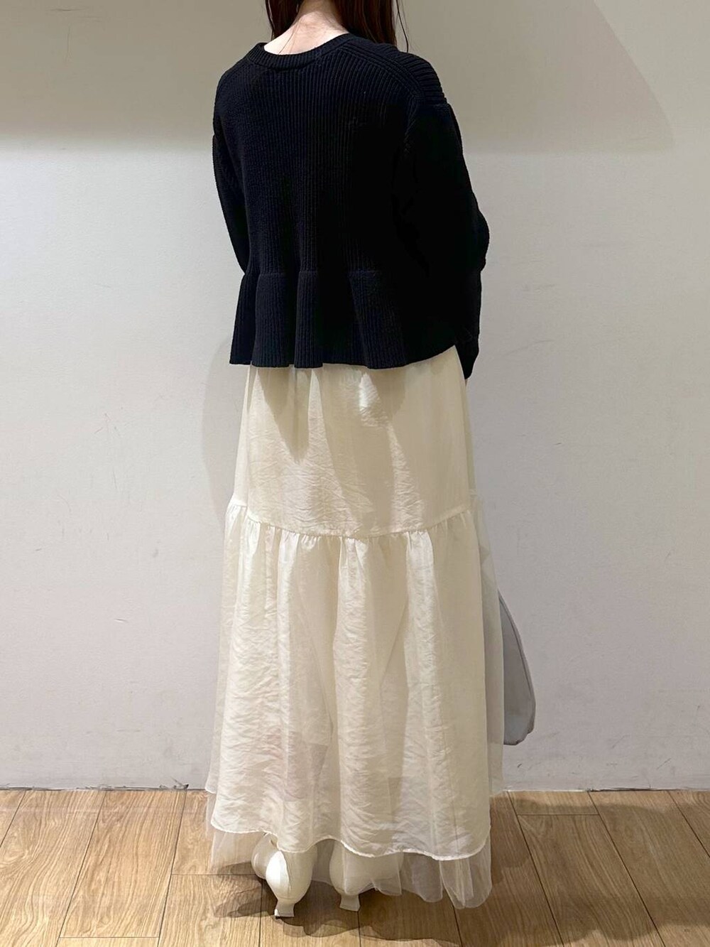 ホワイト系のブーツ、ホワイト系のスカート、グレー系のトートバッグを着用したレディースの冬コーディネートの4枚目の写真